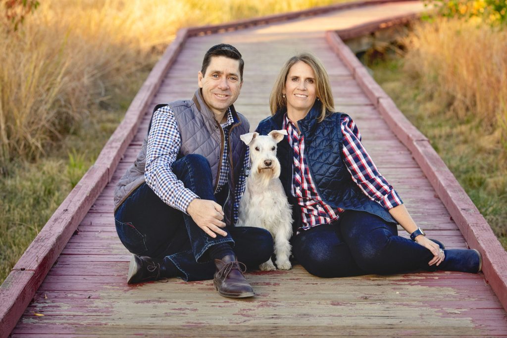 couple outside with small white dog