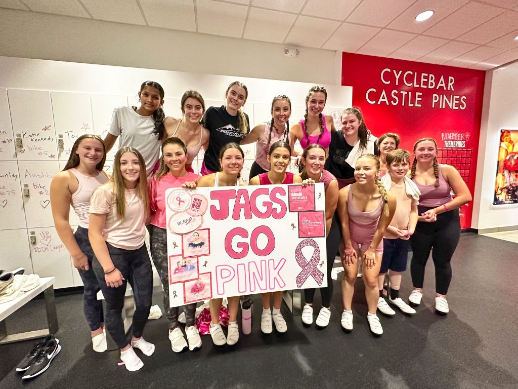 group of ladies at workout studio holding sign