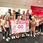 group of ladies at workout studio holding sign