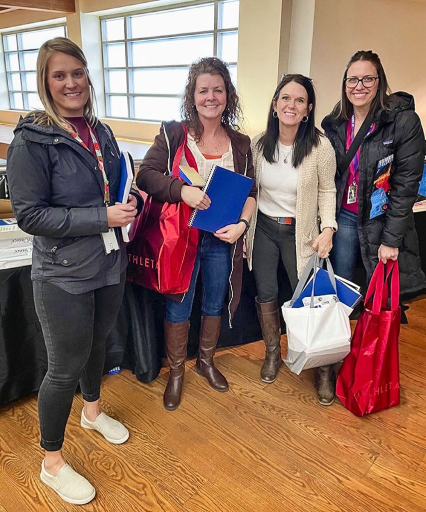 four teachers stand holding donations