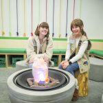 two girls sitting by faux fire