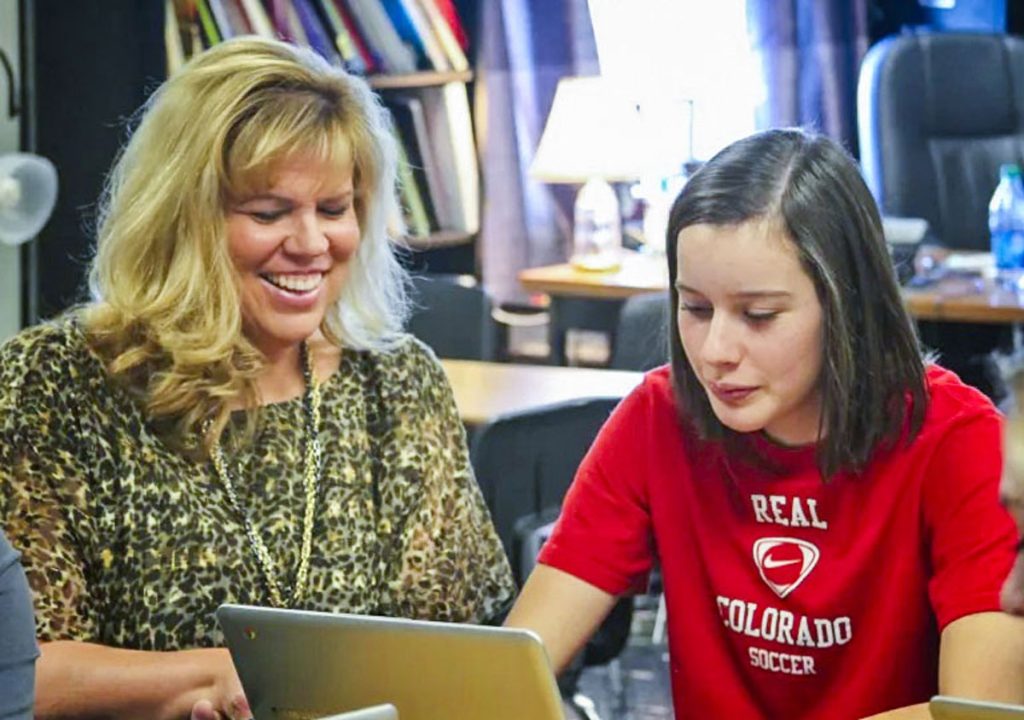 teacher and student looking at laptop