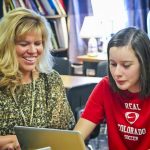 teacher and student looking at laptop