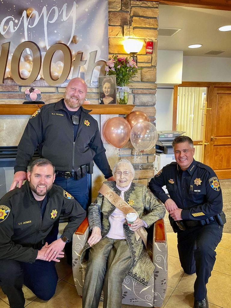 senior lady sitting with police officers around her