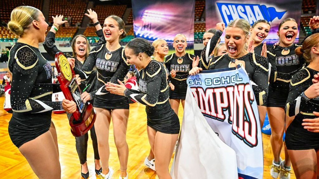 student athletes smiling and holding banner