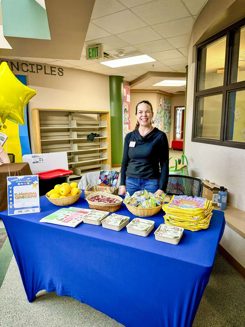 lady standing behind vendor table selling