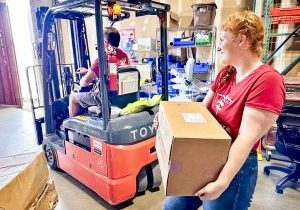 Project C.U.R.E. volunteers at the headquarters in Colorado load a cargo container, prepping it for shipping to an area in need. 