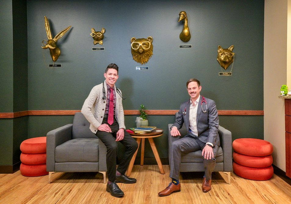 Aaron Block, M.D. (right) and John Waters (left) opened The Cove Concierge Medicine in Castle Rock in 2024. The golden heads on the wall are characters from Canadian author Jessica Hiemstra. Dr. Block and John consider them “our Cove Guardians” as they bring a sense of nature and wonder to the waiting room.