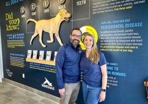 Jim and Christy Boswell in front of the Knowledge Wall at their Scenthound location in Parker.
