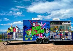 Kellie Brown, Jimmy Brown, Brittany Wiesinger and James Wiesinger, all business owners of Pop Claw, and Carter Brown, Morgan Brown, Campbell Wiesinger and Palmer Wiesinger, the children of Pop Claw co-owners, gather for a photo on the Pop Claw mobile arcade trailer.