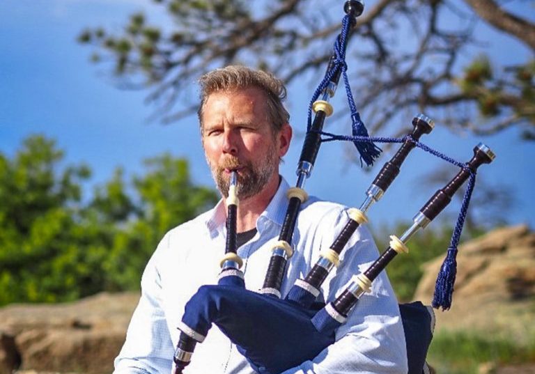 Forrest Plesko bagpiping with a view at Daniels Park in June 2026.