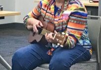 A High Prairie Storytellers volunteer incorporates playing guitar into oral storytelling.