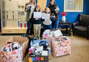 Brothers Mason and Maverick Metcalf, who enjoy helping those in need, proudly collected 3,258 pairs out of the total 4,682 socks raised at this year’s “Sock it to ‘Em” drive at American Academy. Pictured: AA elementary Principal Lisa Anthenien, Mason Metcalf, Maverick Metcalf and middle school Principal Michelle Daley. 