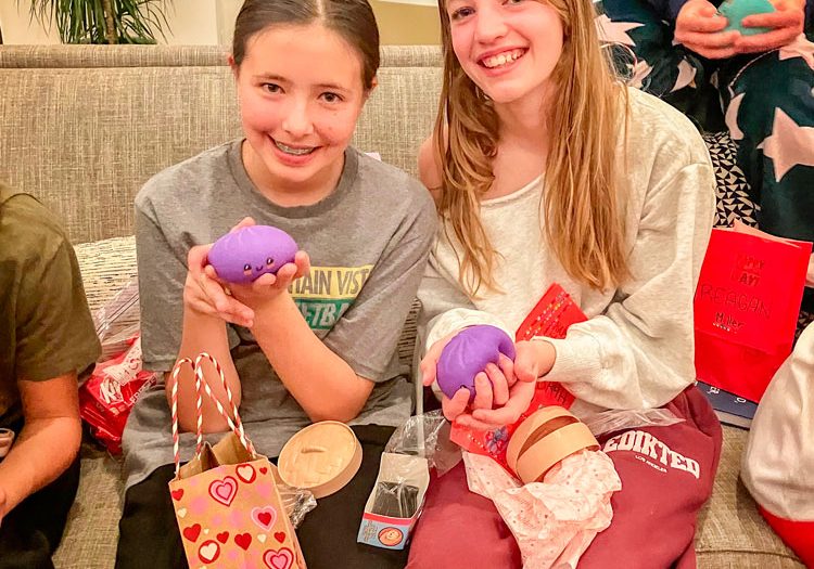 Two soccer teammates excited after opening Rainbow Mystery Dumplings they received from a teammate in a Valentine’s gift exchange.