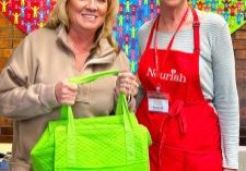 Hidden Pointe resident, Hollen Wheeler, shown here (left) picking up a meal bag, has been delivering meals for Nourish Meals on Wheels since 2018. She loves her Friday route! Pictured also is Susan Bechler, a volunteer in the kitchen.