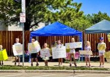 Crocs swimmers advertise fresh lemonade with homemade signs. The proceeds went to Make-A-Wish Foundation.