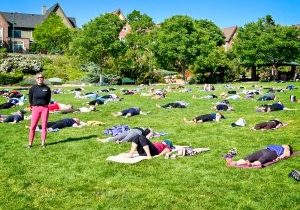 Elizabeth Potarf teaching an outdoor yoga class where participants are in savasana (corpse pose), a deeply relaxing final yoga posture. 